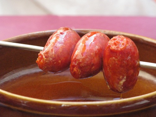 Yum!! Lunchtime. A skewer of small sausages flamed at table.