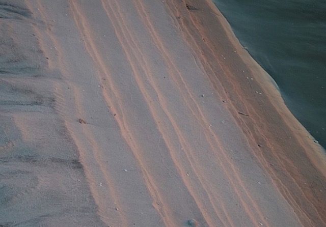 The edge of a sandbar at sunset.